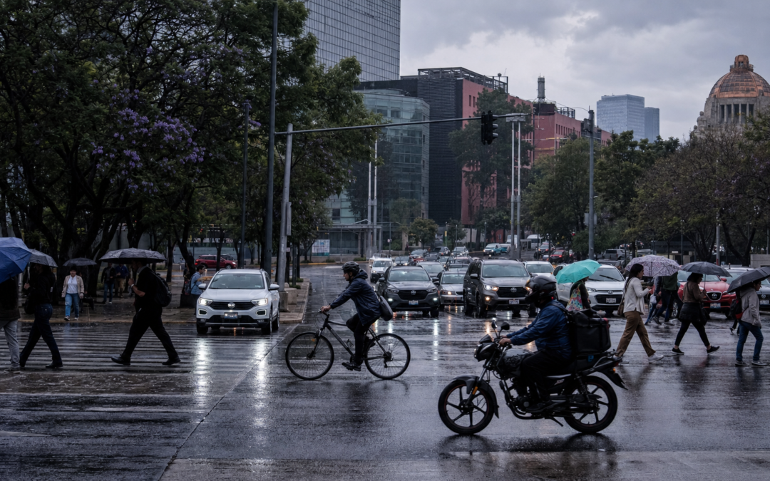 Automóviles avanzan lentamente sobre una avenida de la Ciudad de México mientras peatones cruzan con paraguas bajo un cielo nublado; al fondo se observan señales viales y edificios urbanos.
