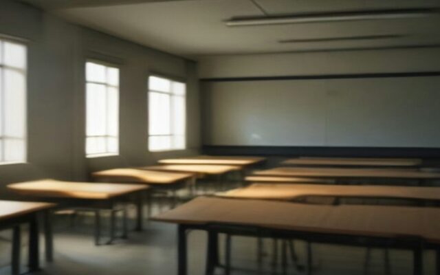 Salón de clases vacío con pupitres de madera alineados y ventanas por las que entra luz de la mañana