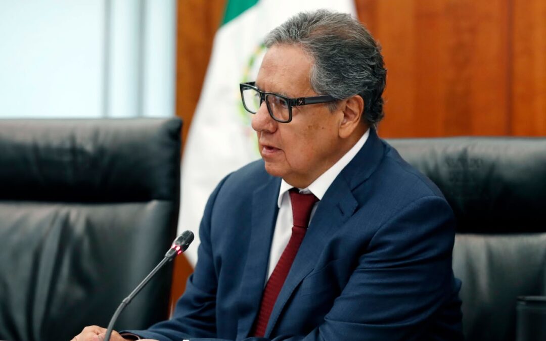El senador Higinio Martínez Miranda, sentado frente a un micrófono en una sala del Senado con la bandera nacional detrás