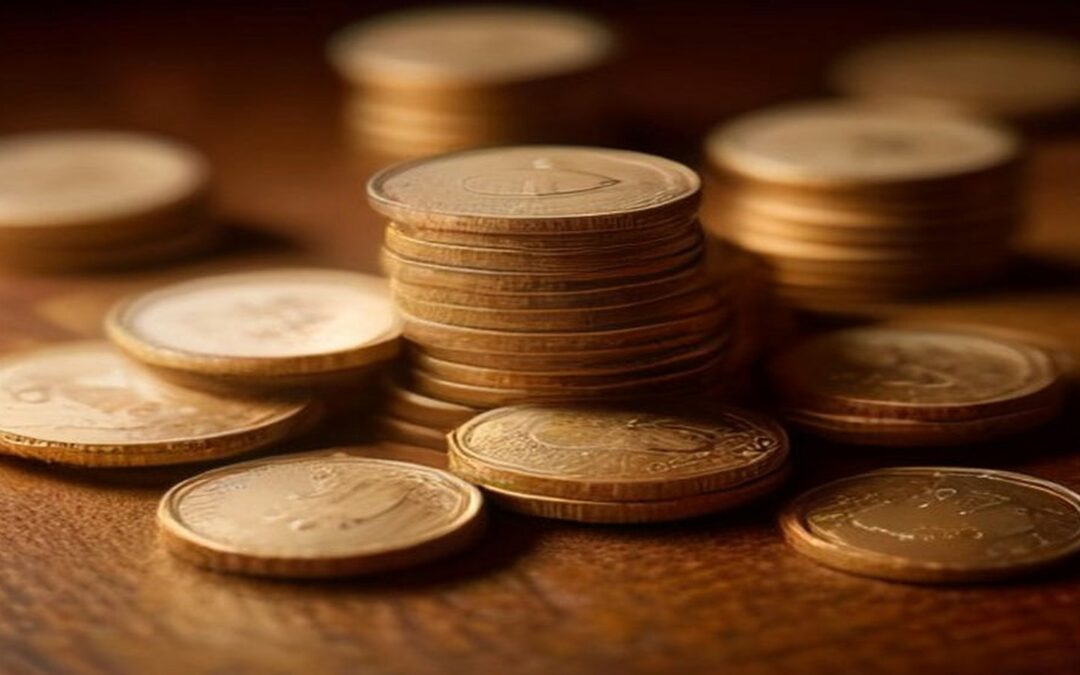 Pilas de monedas doradas sobre una mesa de madera oscura, con más monedas desenfocadas al fondo e iluminación cálida